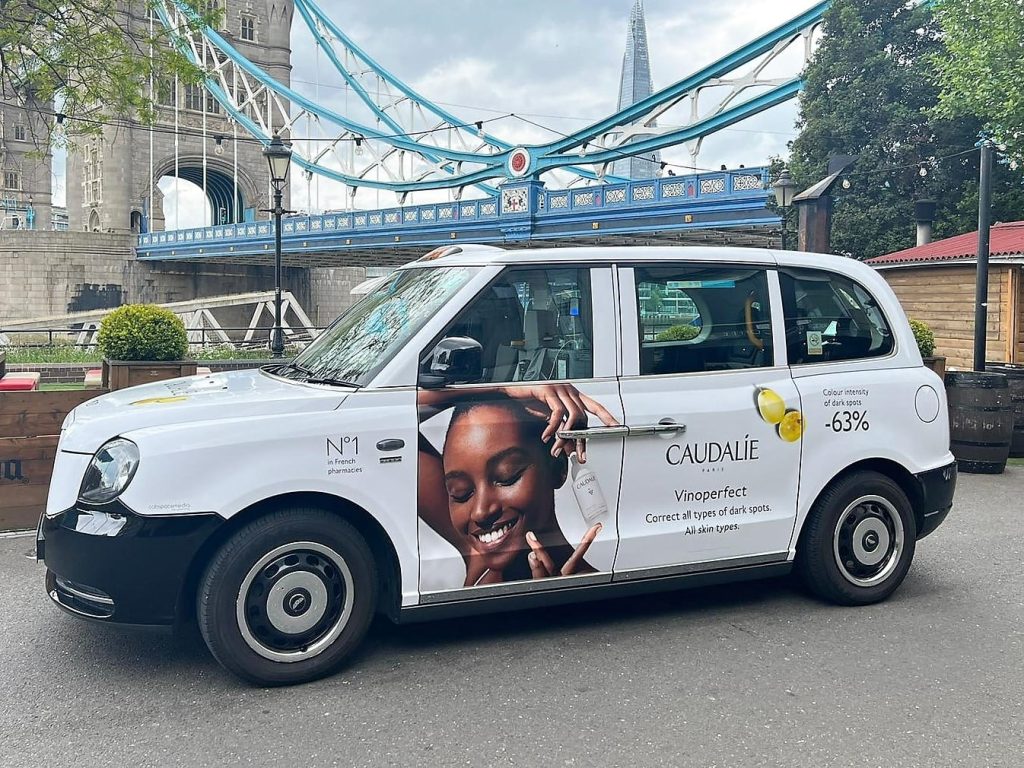 Caudalie advertising campaign on a London taxi beside Tower Bridge