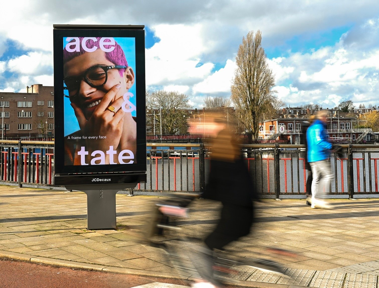 Ace & Tate digital out-of-home campaign beside a busy urban walkway