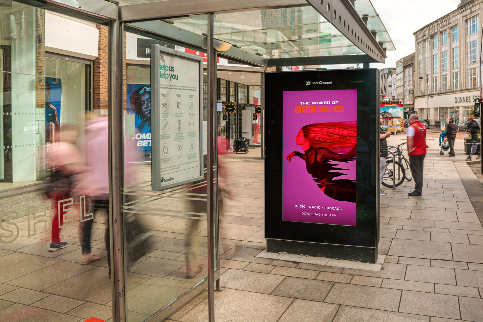 BBC Sounds digital advertising display beside a city bus shelter
